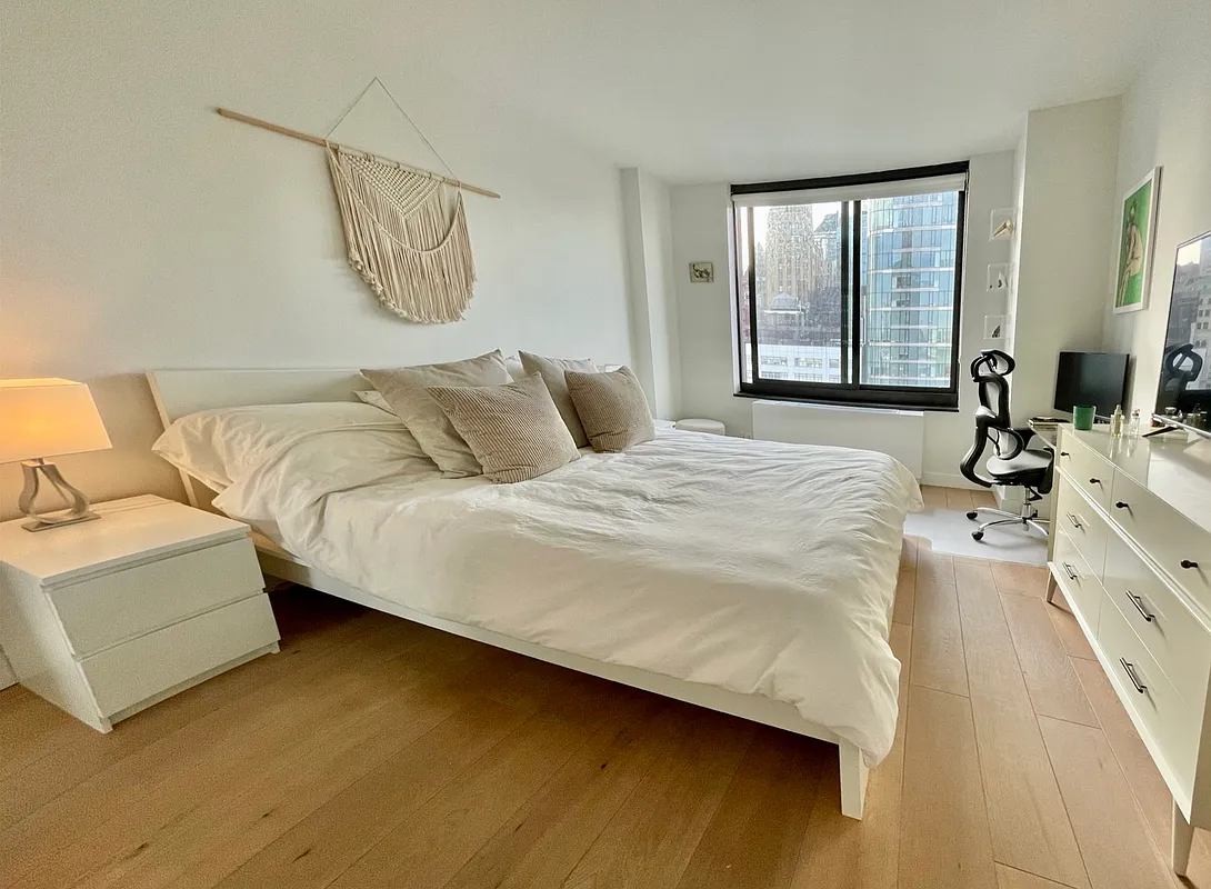 200 Rector Place, Unit 37J Manhattan, NY 10280 - Photo 4 of 12 a bedroom with a bed couch and a window