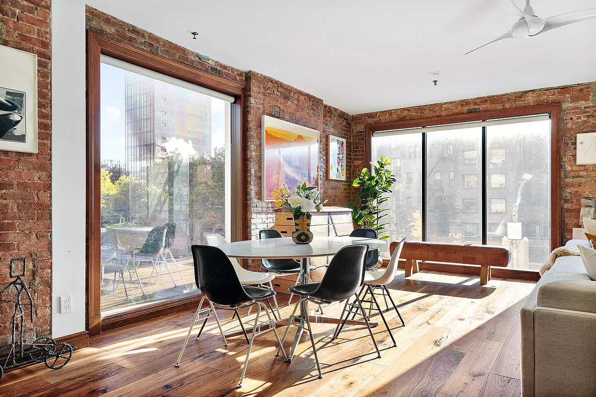 115 Allen Street, Unit 3 Manhattan, NY 10002 - Photo 5 of 13 a view of a dining room with furniture large windows and wooden floor