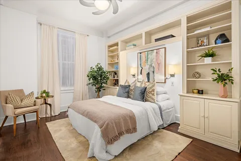 a bedroom with a large bed and a potted plant