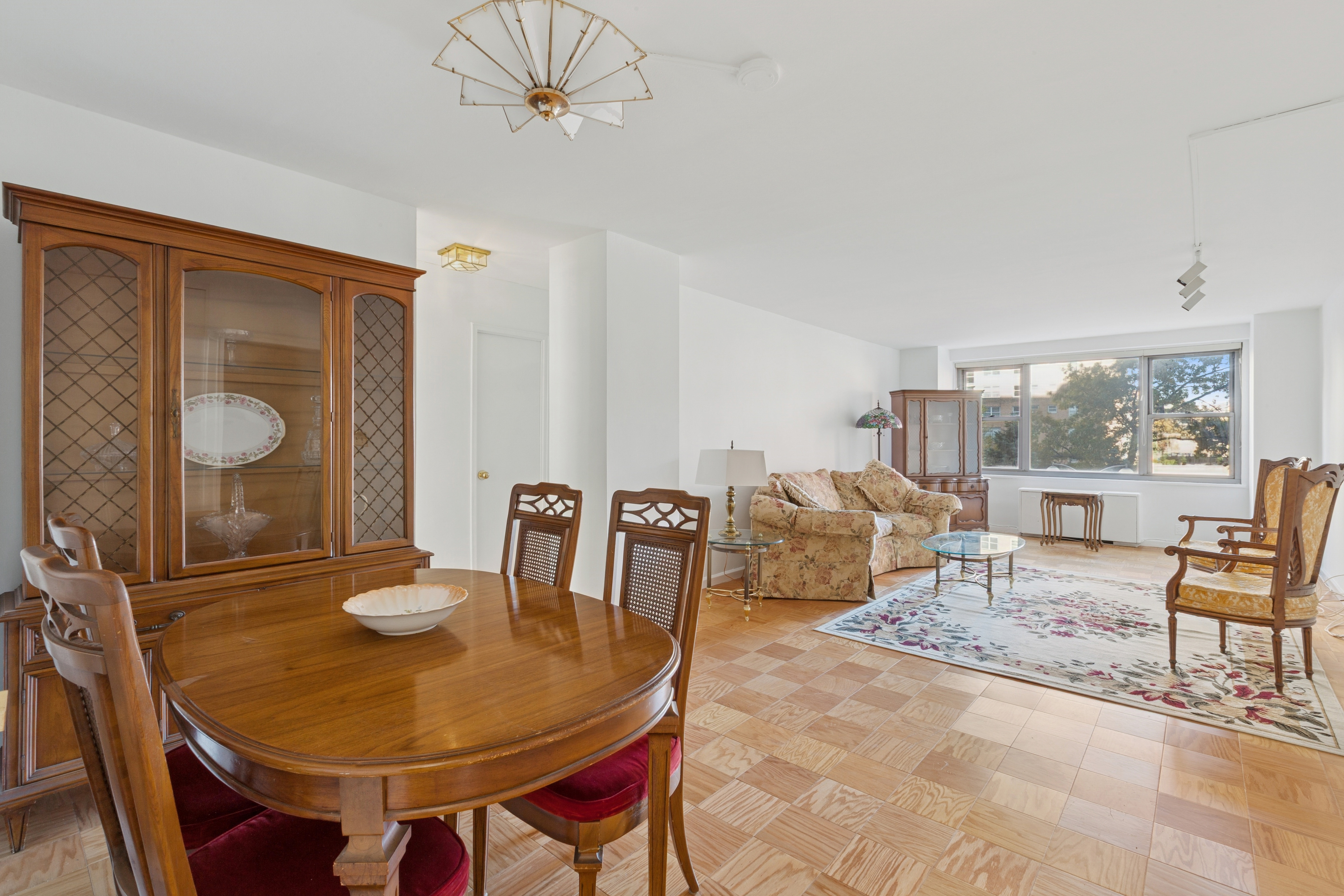 70-25 Yellowstone Boulevard, Unit 2M Queens, NY 11375 - Photo 2 of 23 a living room with furniture a window and a table