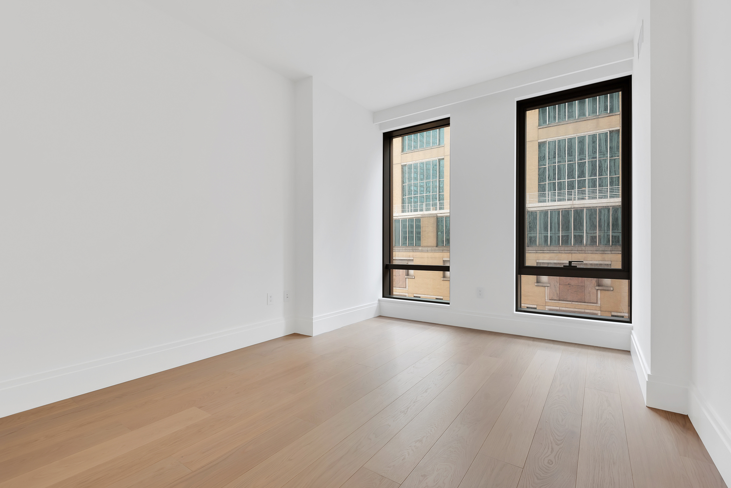 50 West 66th Street, Unit 7B Manhattan, NY 10023 - Photo 13 of 24 an empty room with wooden floor and windows