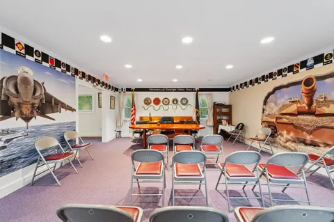 a living room with furniture a rug and a projector