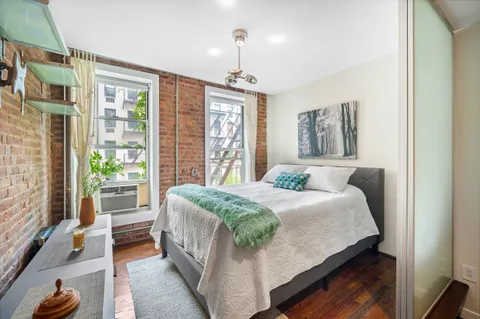 a bed sitting in a bedroom next to a window