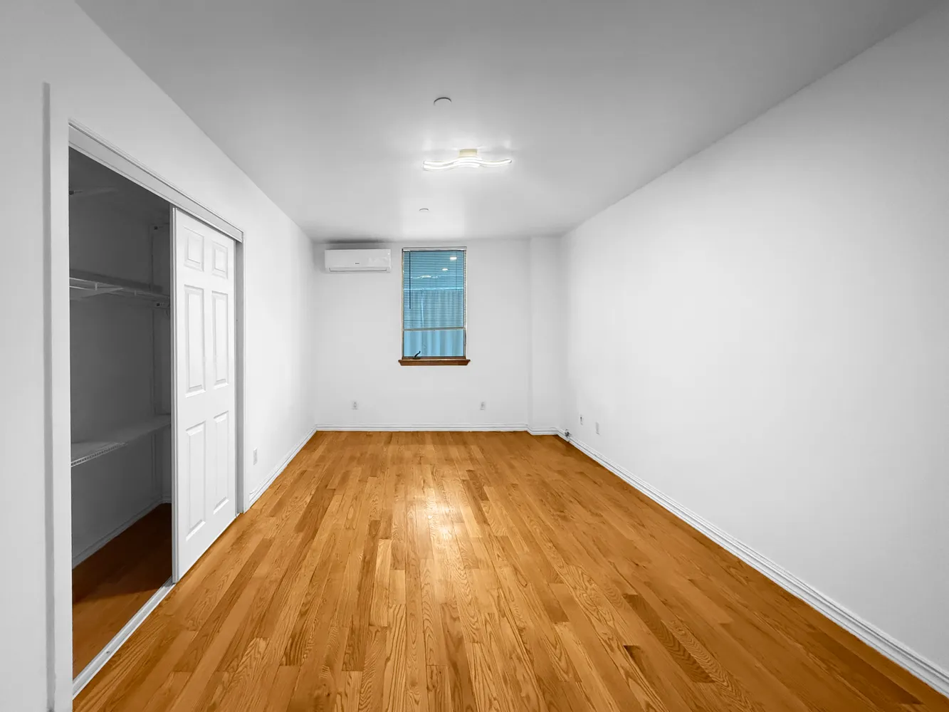 a view of empty room with wooden floor