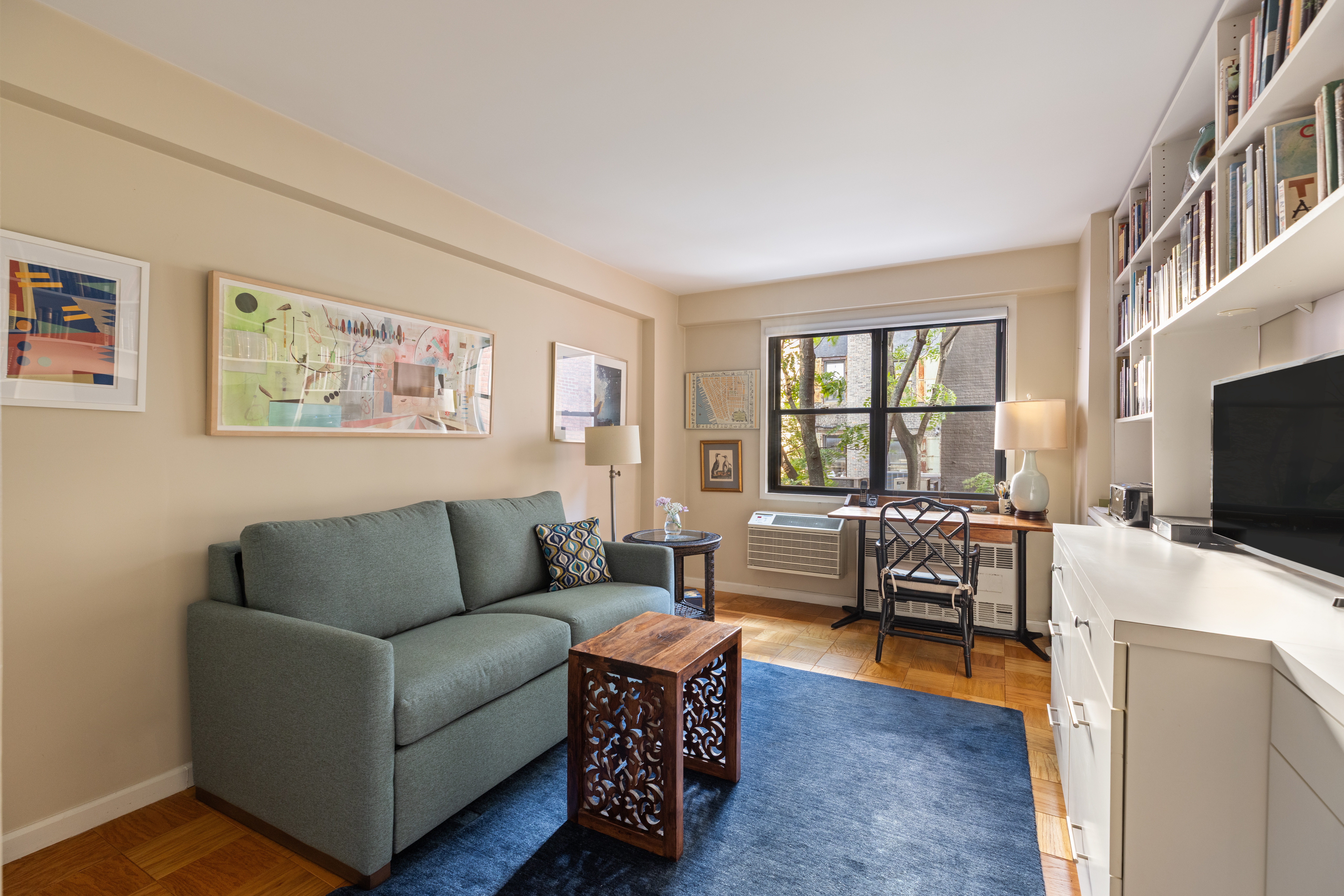 31 Jane Street, Unit 3H Manhattan, NY 10014 - Photo 10 of 14 a living room with furniture and a flat screen tv with wooden floor
