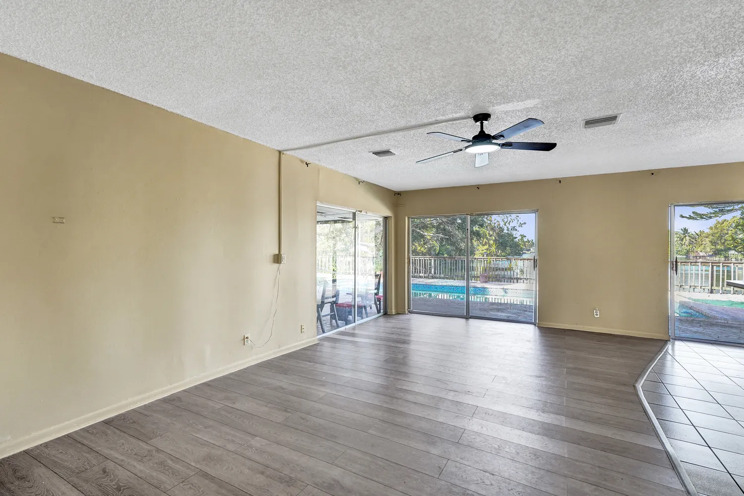 a view of an empty room with a window and wooden floor
