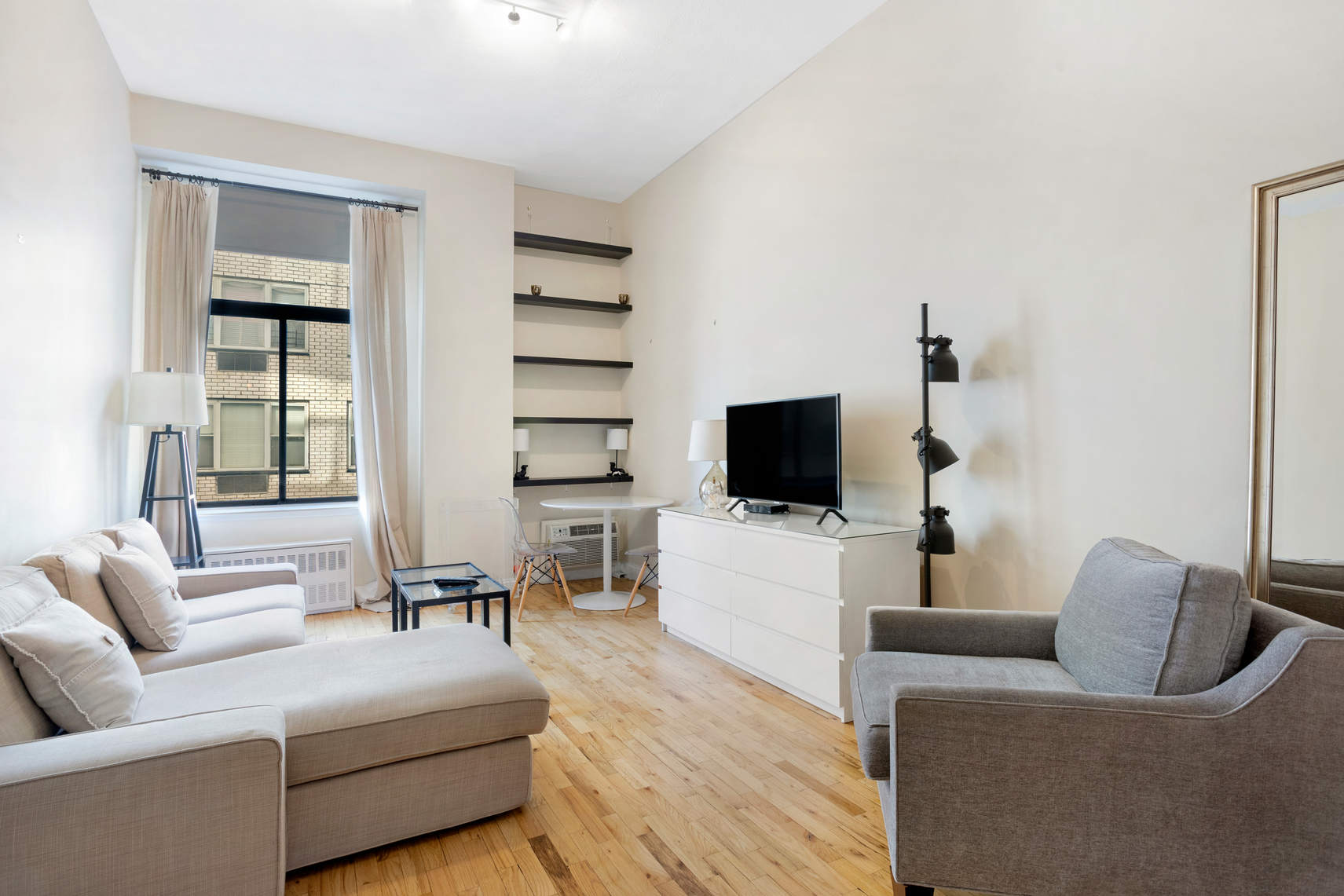 310 East 23rd Street, Unit 7C Manhattan, NY 10010 - Photo 4 of 18 a living room with furniture and a flat screen tv