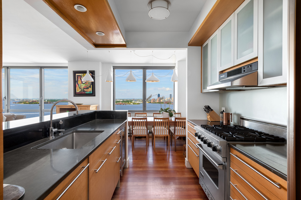 30 West Street, Unit 19F Manhattan, NY 10004 - Photo 3 of 12 a kitchen with stainless steel appliances granite countertop a stove and a sink