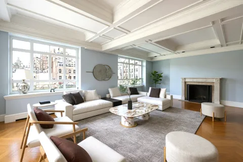 a living room with furniture a fireplace and a large window
