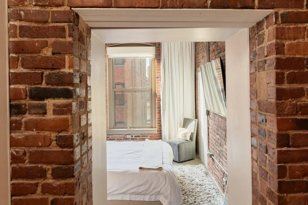 a view of a bedroom with wooden floor and windows