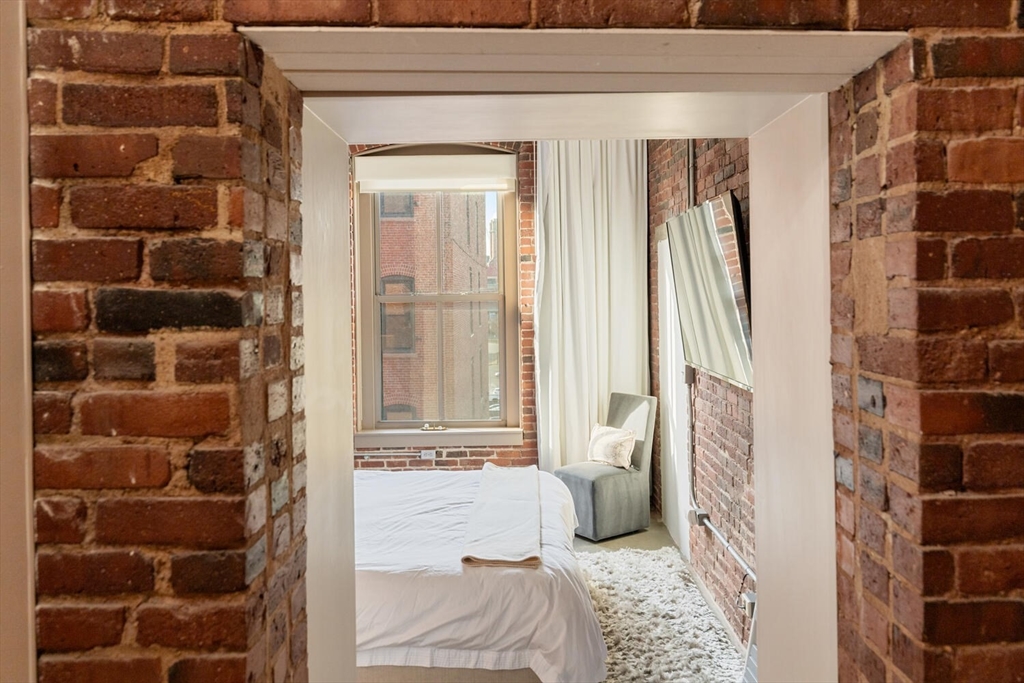 35 Channel Center Street, Unit 402 Boston, MA 02210 - Photo 18 of 35 a view of a bedroom with wooden floor and windows