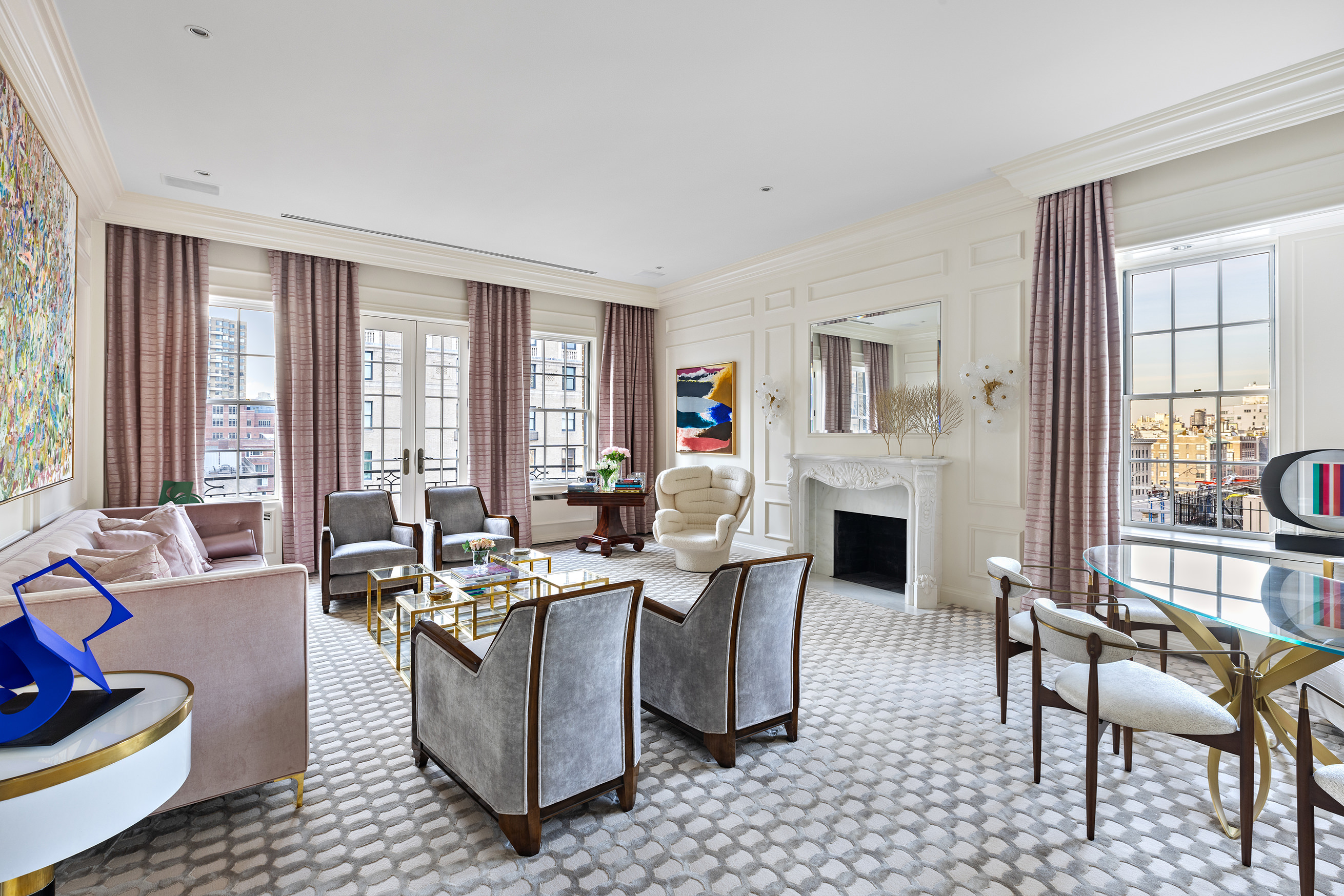 a living room with furniture a fireplace and large windows