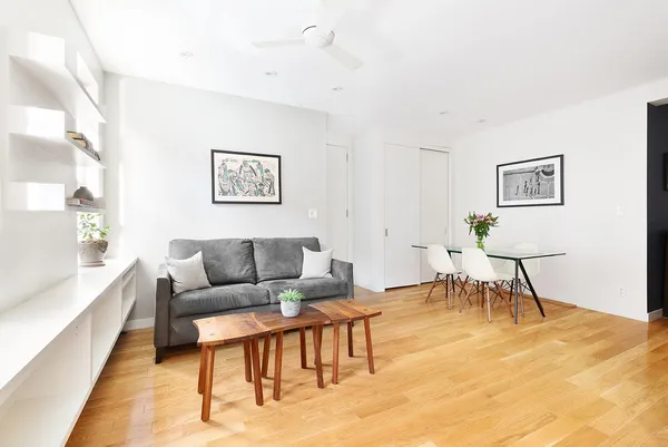 a living room with furniture and a dining table with rug