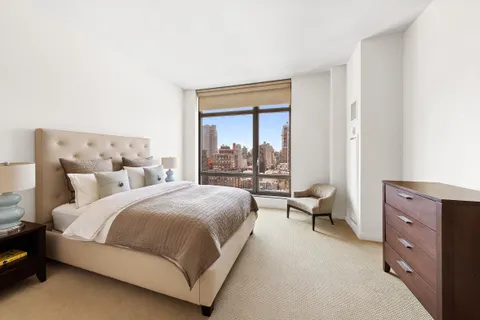a bedroom with a bed and large window