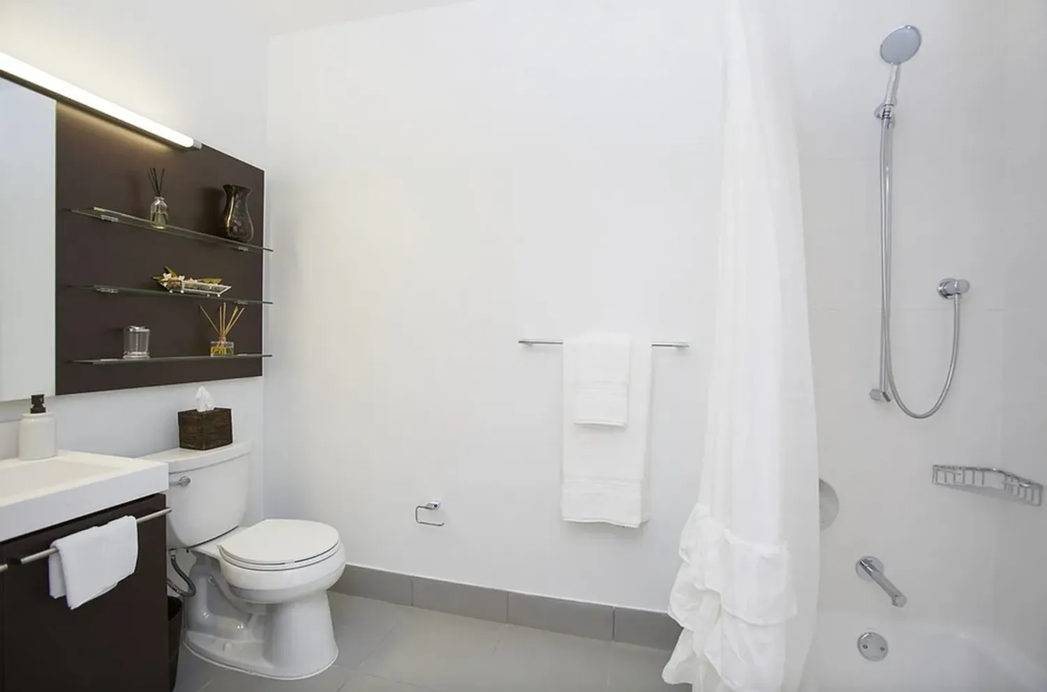 a white toilet sitting next to a bathroom sink and a shower