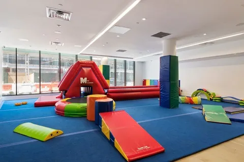 a play room with furniture and a floor to ceiling window