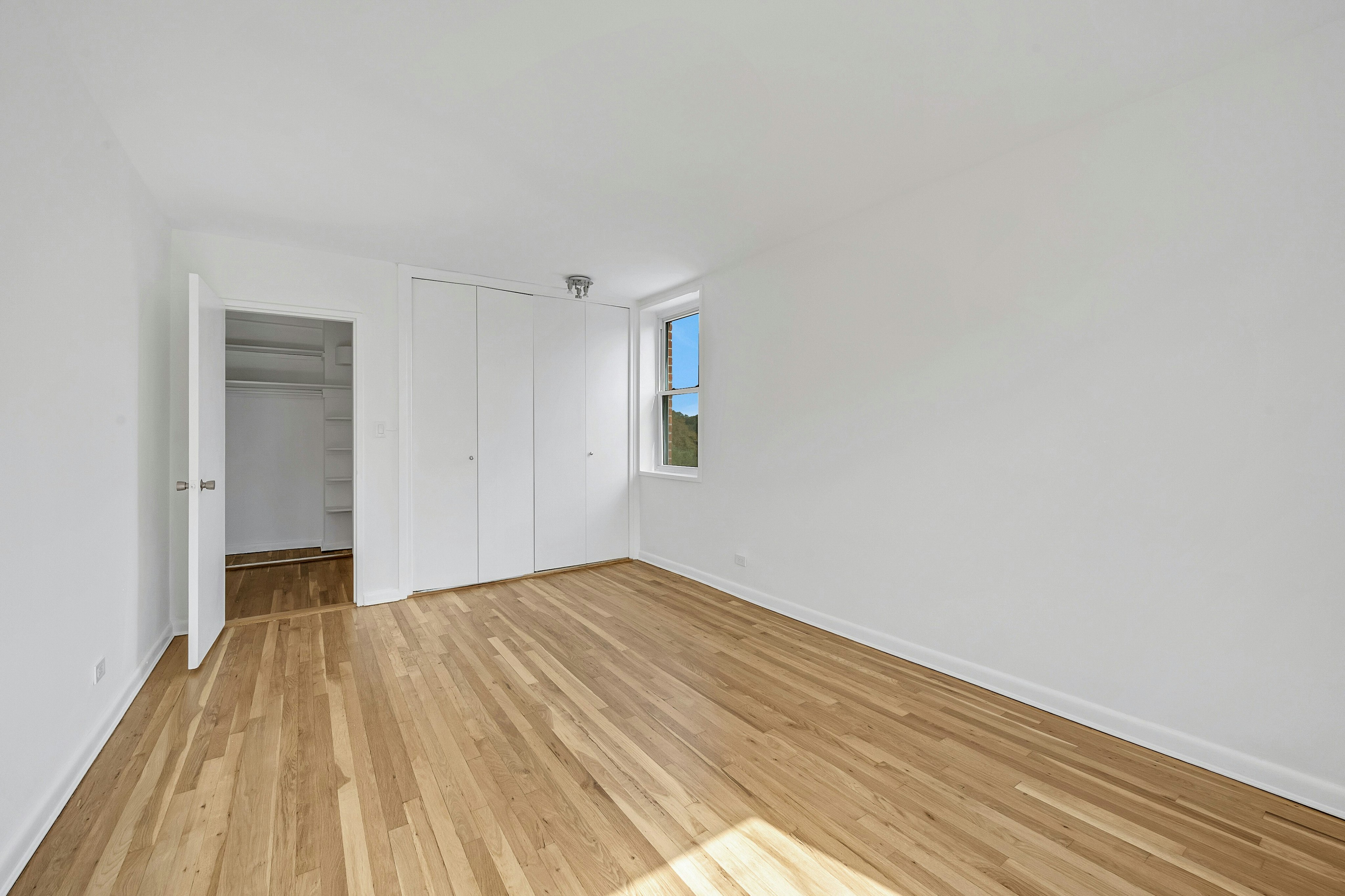 5730 Mosholu Avenue, Unit 5F Bronx, NY 10471 - Photo 13 of 15 a view of an empty room with wooden floor and a window