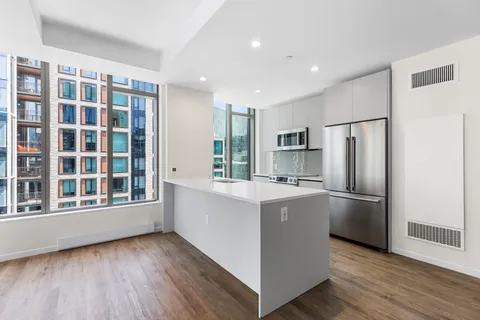 a kitchen with stainless steel appliances granite countertop a refrigerator and a stove top oven