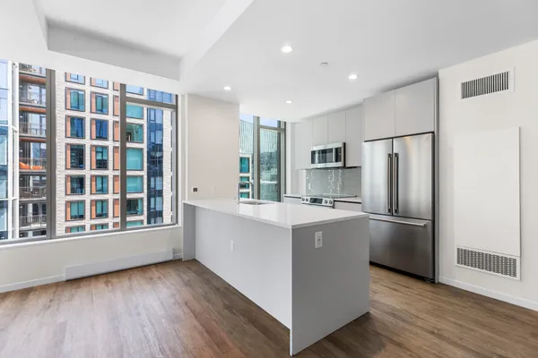 a kitchen with stainless steel appliances granite countertop a refrigerator and a stove top oven