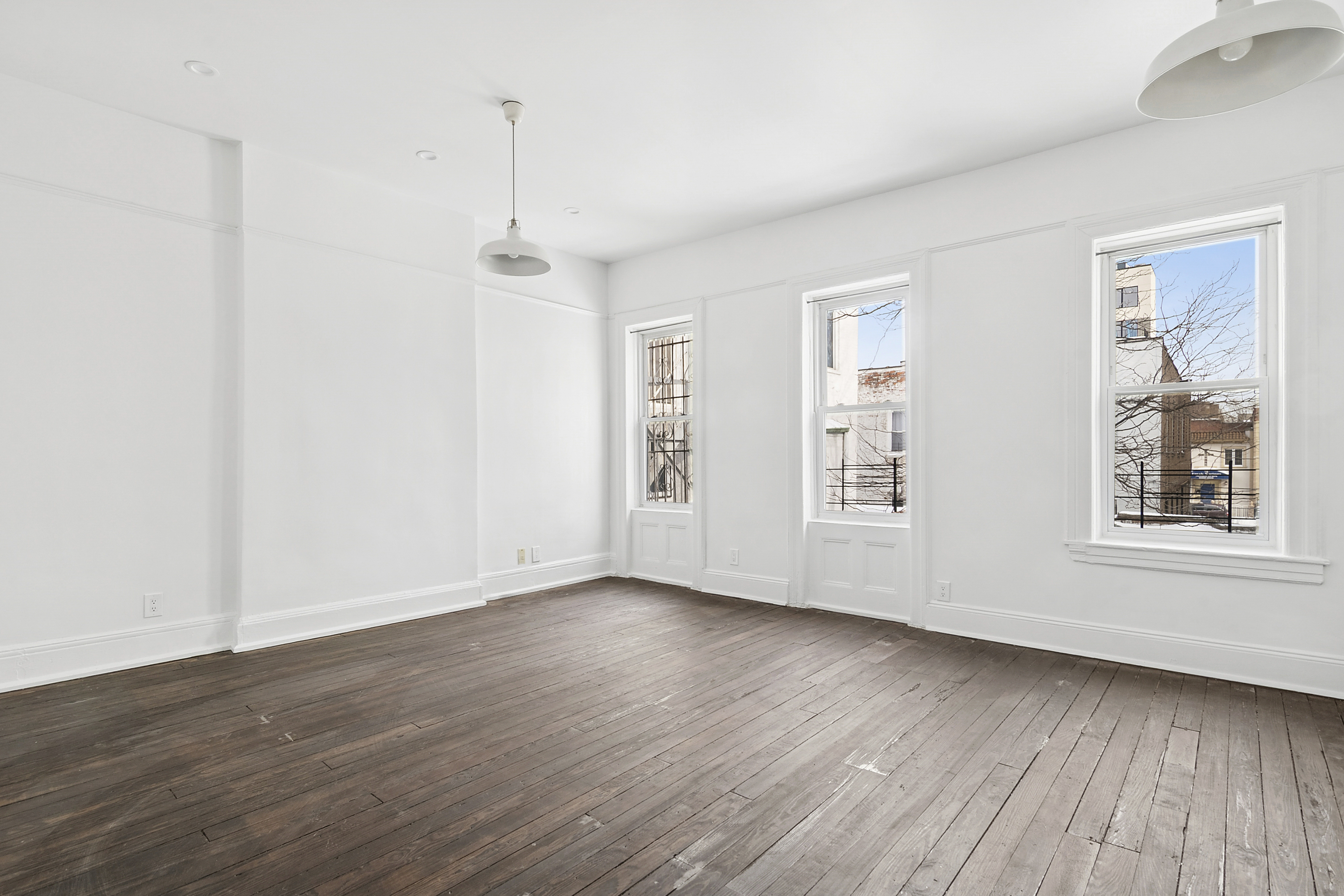 239 East 23rd Street, Unit 2 Brooklyn, NY 11226 - Photo 3 of 8 a view of an empty room with wooden floor and a window