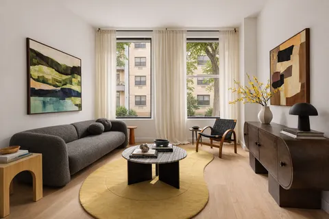 a living room with fireplace furniture and a large window