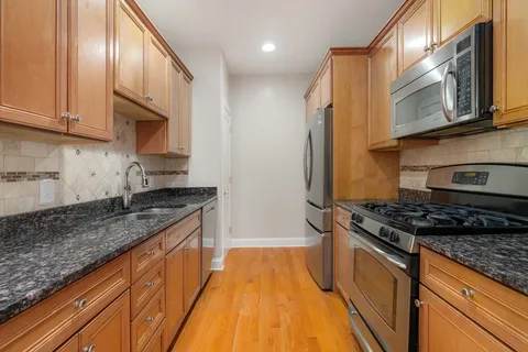 a kitchen with stainless steel appliances granite countertop a stove and a sink