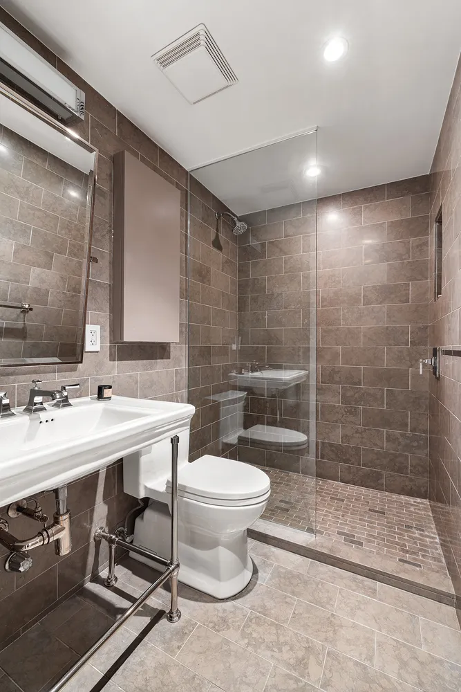 a bathroom with a sink a toilet and shower