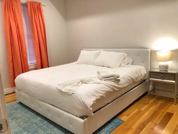 a large bed sitting in a bedroom next to a lamp