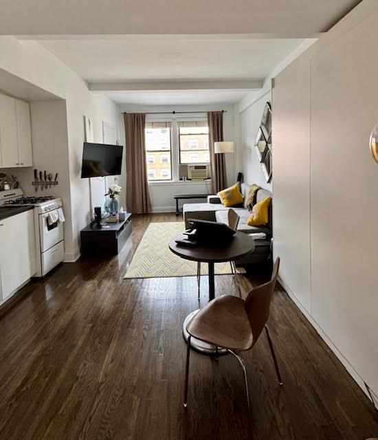 a living room with furniture a flat screen tv and a window