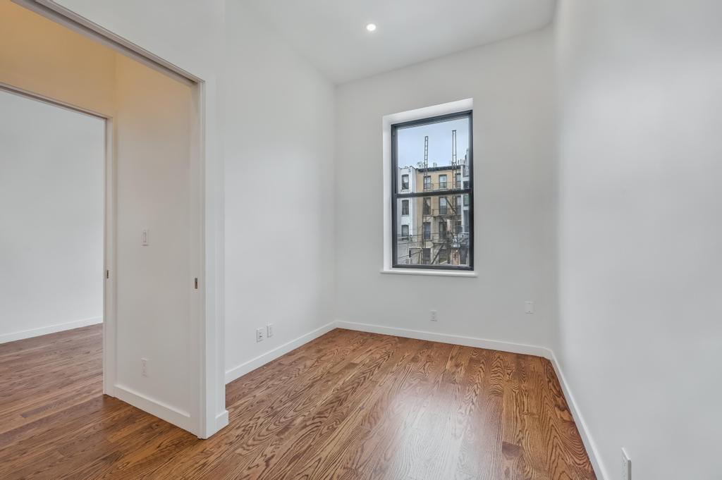 109 President Street, Unit 2 Brooklyn, NY 11231 - Photo 15 of 20 an empty room with wooden floor and windows