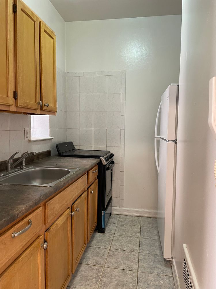 1280 Dean Street, Unit 3E Brooklyn, NY 11216 - Photo 2 of 5 a kitchen with a sink and a refrigerator