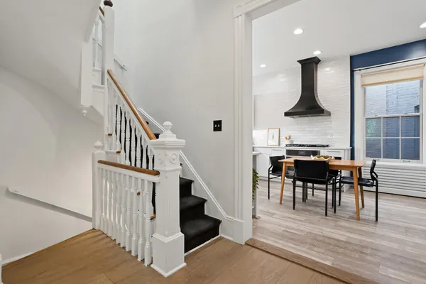 a view of entryway and dining room with wooden floor