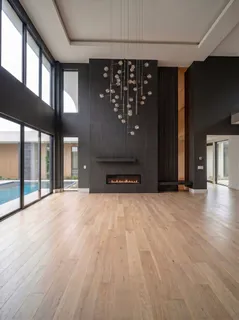 en empty room with wooden floor and windows