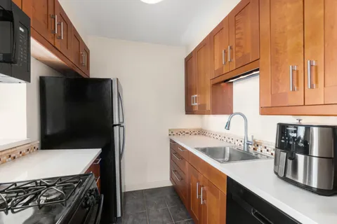a kitchen with a sink stove top oven and cabinets
