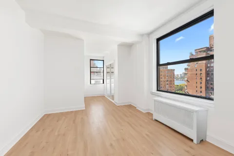 an empty room with wooden floor and a window