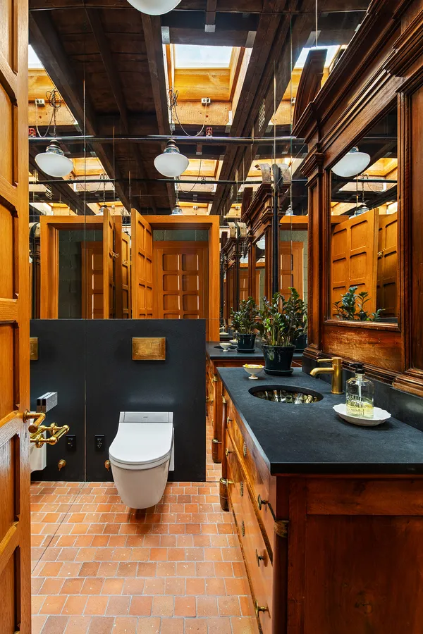 a bathroom with stainless steel appliances a sink and a wooden floor