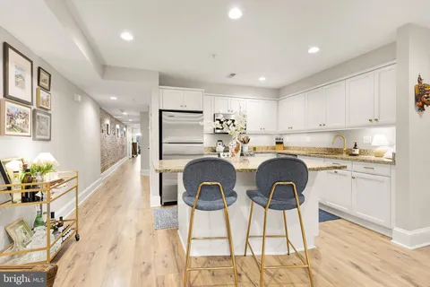 a kitchen with kitchen island a stove a table and chair in it