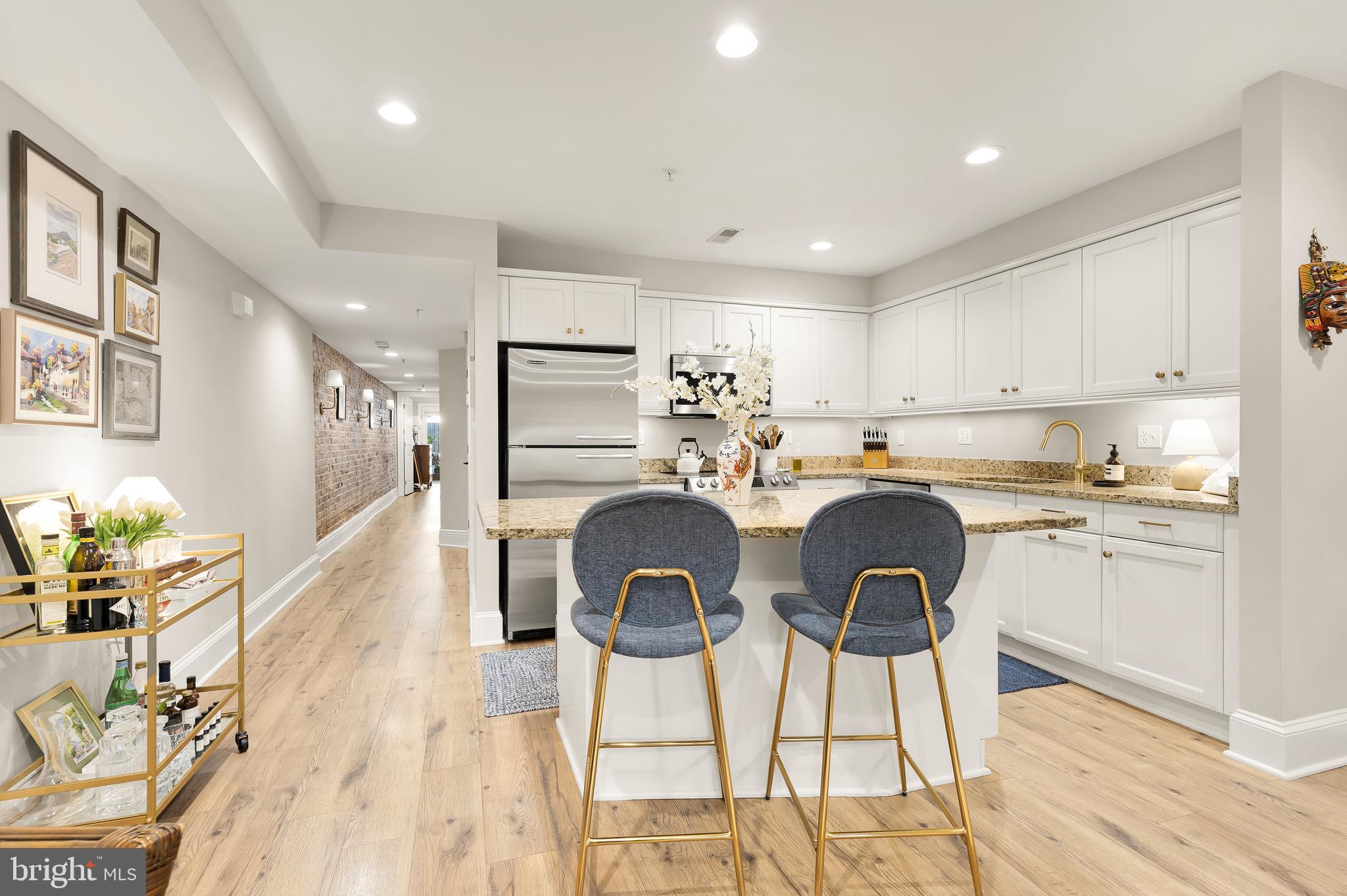 1354 Kenyon Street Northwest, Unit G Washington, DC 20010 - Photo 11 of 37 a kitchen with kitchen island a stove a table and chair in it