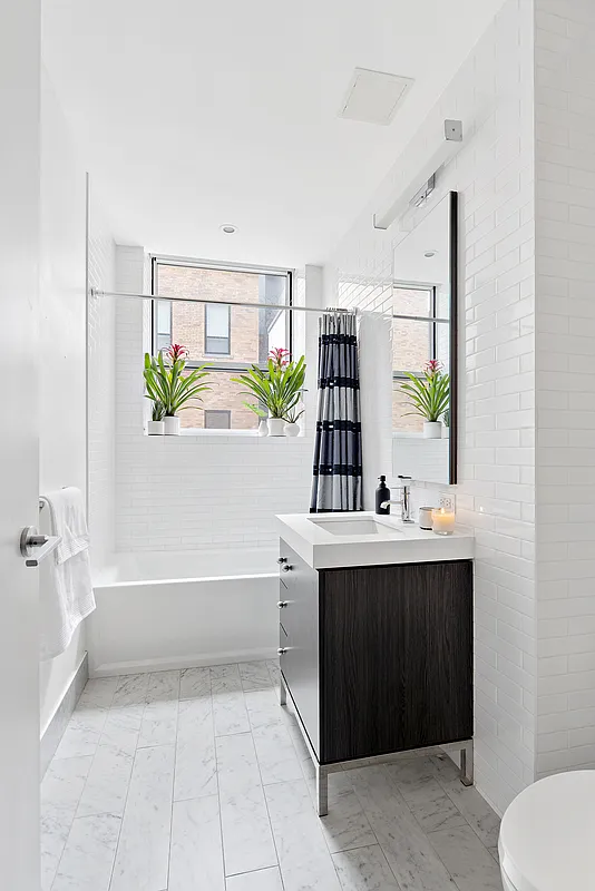 416 West 52nd Street, Unit 523 Manhattan, NY 10019 - Photo 5 of 16 a bathroom with a bathtub sink and mirror