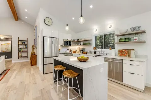 a kitchen with a sink a refrigerator and cabinets
