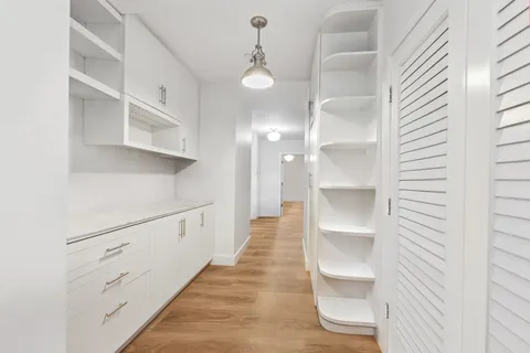 a view of a kitchen with cabinets and wooden floor