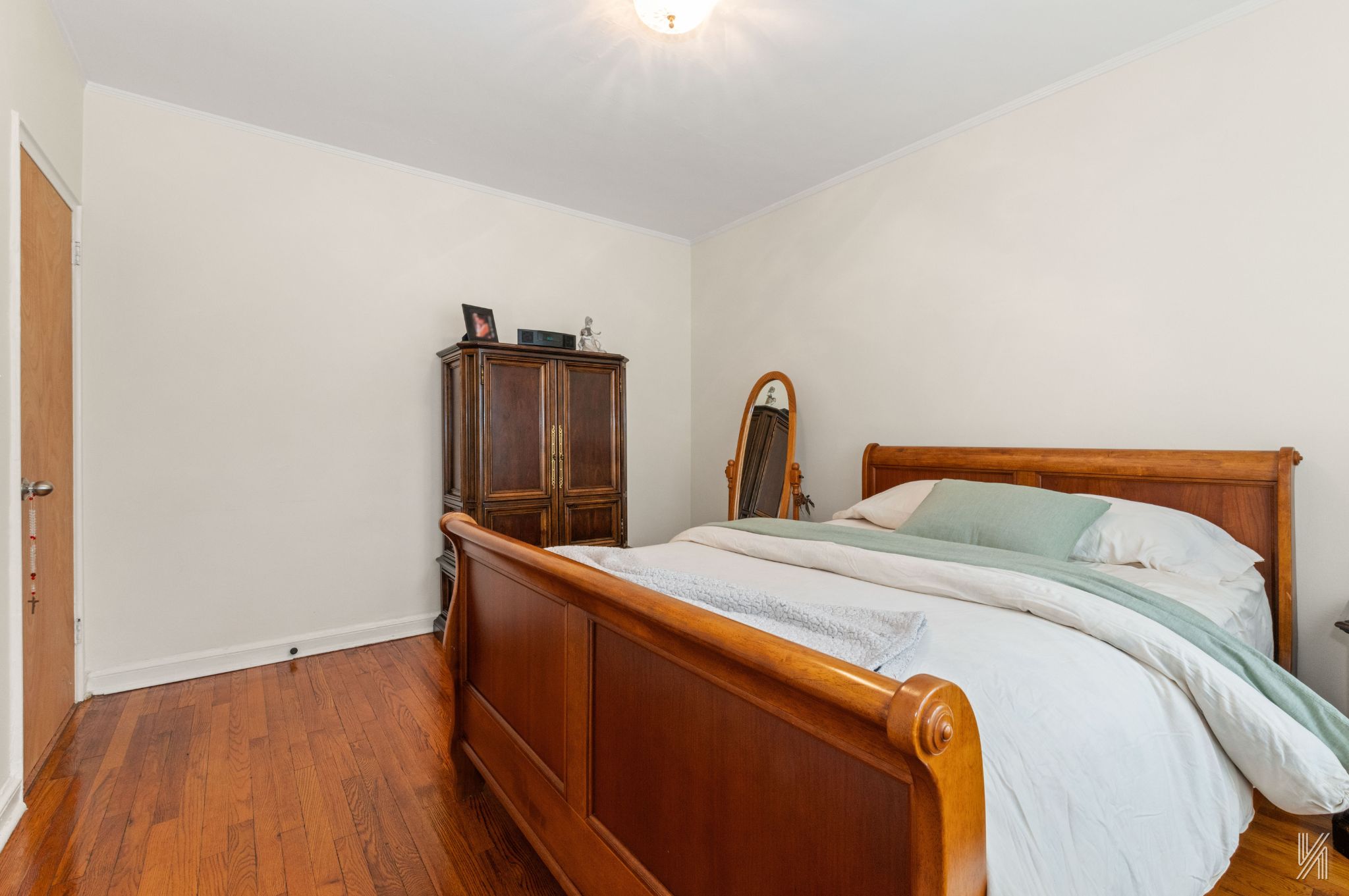 22-08 76th Street, Unit D2 Queens, NY 11370 - Photo 15 of 20 a bed sitting in a bedroom next to a window