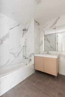 a bathroom with a double vanity sink a mirror and a bathtub