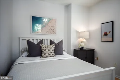 a bedroom with a bed and painting on the wall