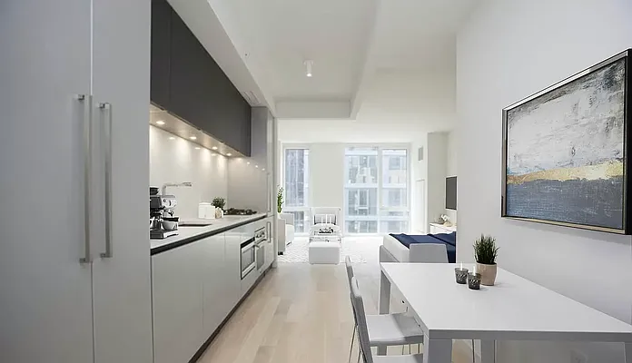 540 West 49th Street, Unit 407N Manhattan, NY 10019 - Photo 6 of 12 a kitchen with stainless steel appliances a sink stove and table