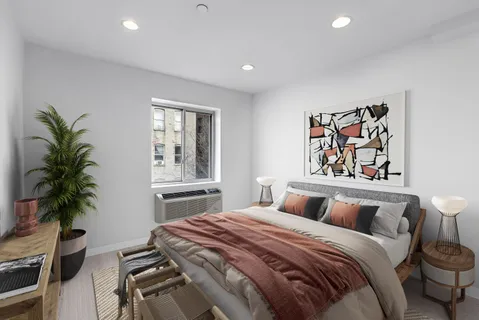 a bedroom with a large bed and a potted plant