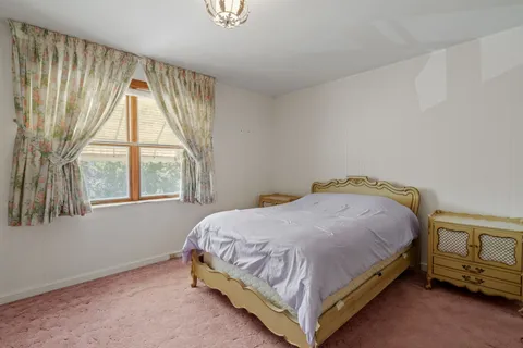 a bed sitting in a bedroom next to a window