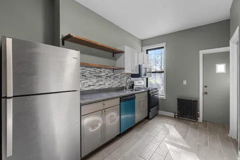 a kitchen with stainless steel appliances granite countertop a refrigerator and a stove