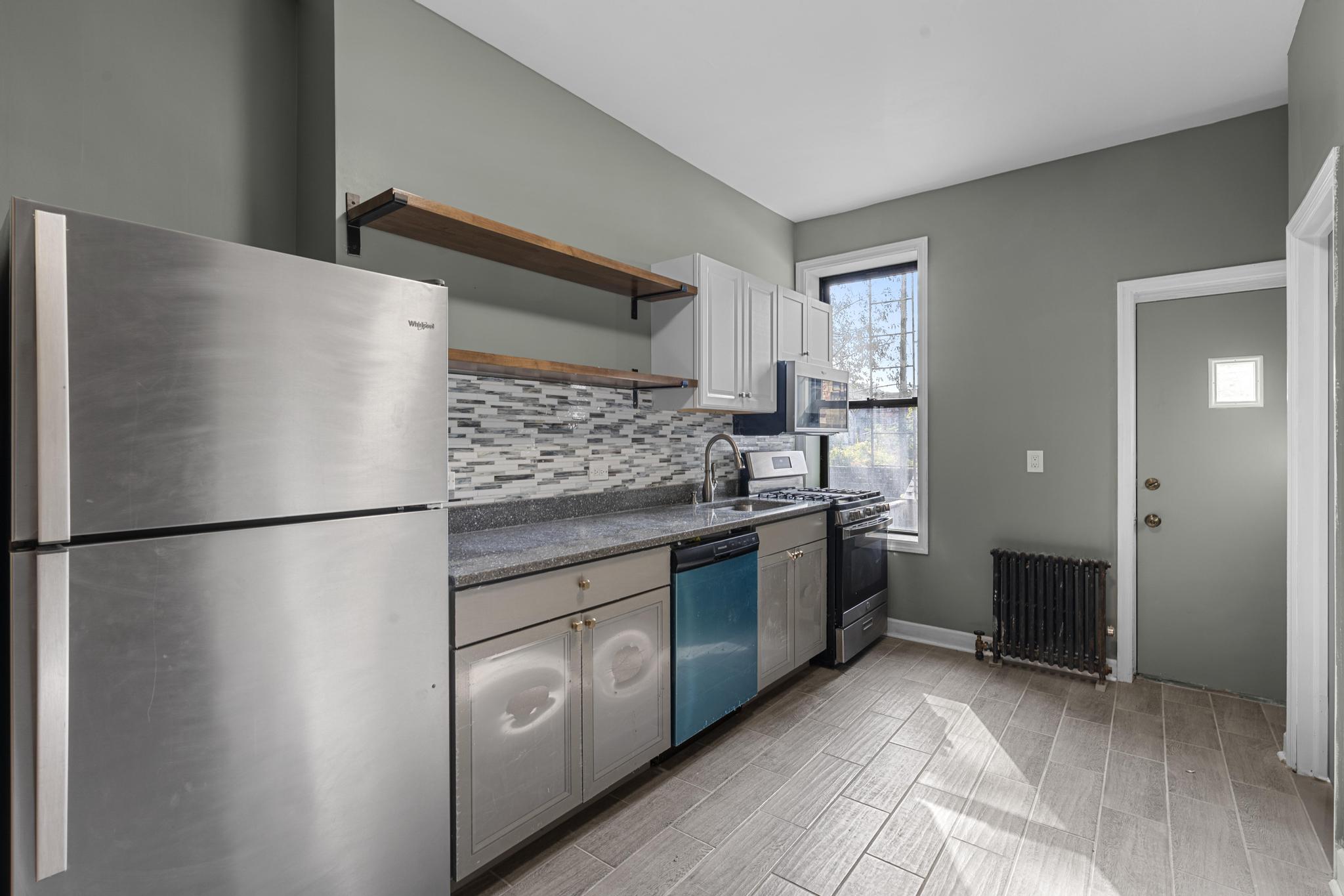 1328 Herkimer Street, Unit 1 Brooklyn, NY 11233 - Photo 2 of 9 a kitchen with stainless steel appliances granite countertop a refrigerator and a stove