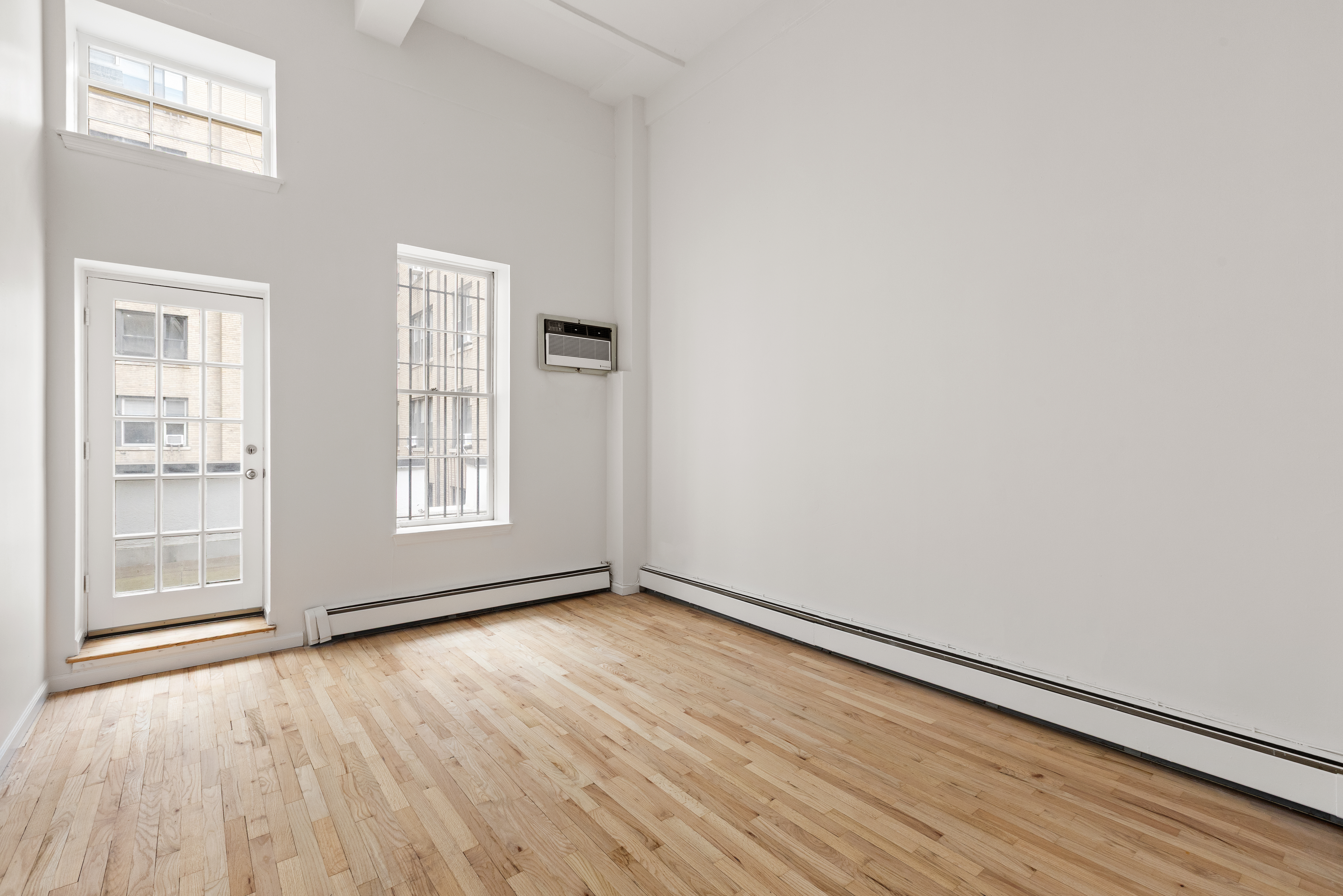 257 West 93rd Street, Unit 3C Manhattan, NY 10025 - Photo 13 of 20 a view of an empty room with wooden floor and a window